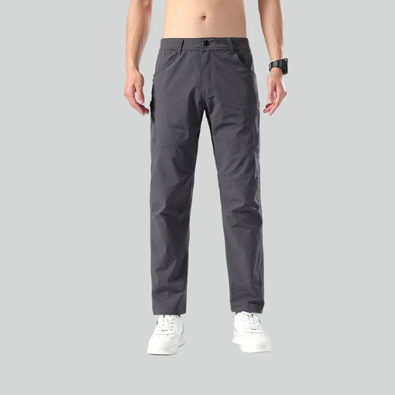 Weatherproof outdoor trousers for men in black, gray, and green colours with adjustable waistband and reinforced panels