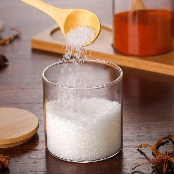 Elegant glass canister with wooden spoon, a versatile kitchen accessory for storing and displaying pantry items