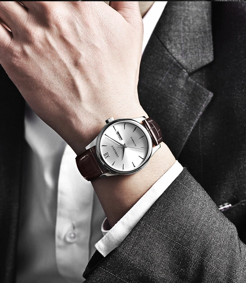 A sophisticated automatic mechanical watch with a gold/white or gold/black face, stainless steel case, and genuine leather strap