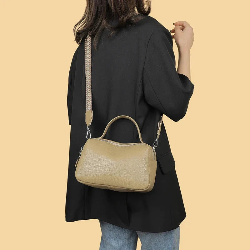 Luxurious genuine leather crossbody bag for women, featuring a soft polyester lining, dual phone pockets, and a compact, square design.
