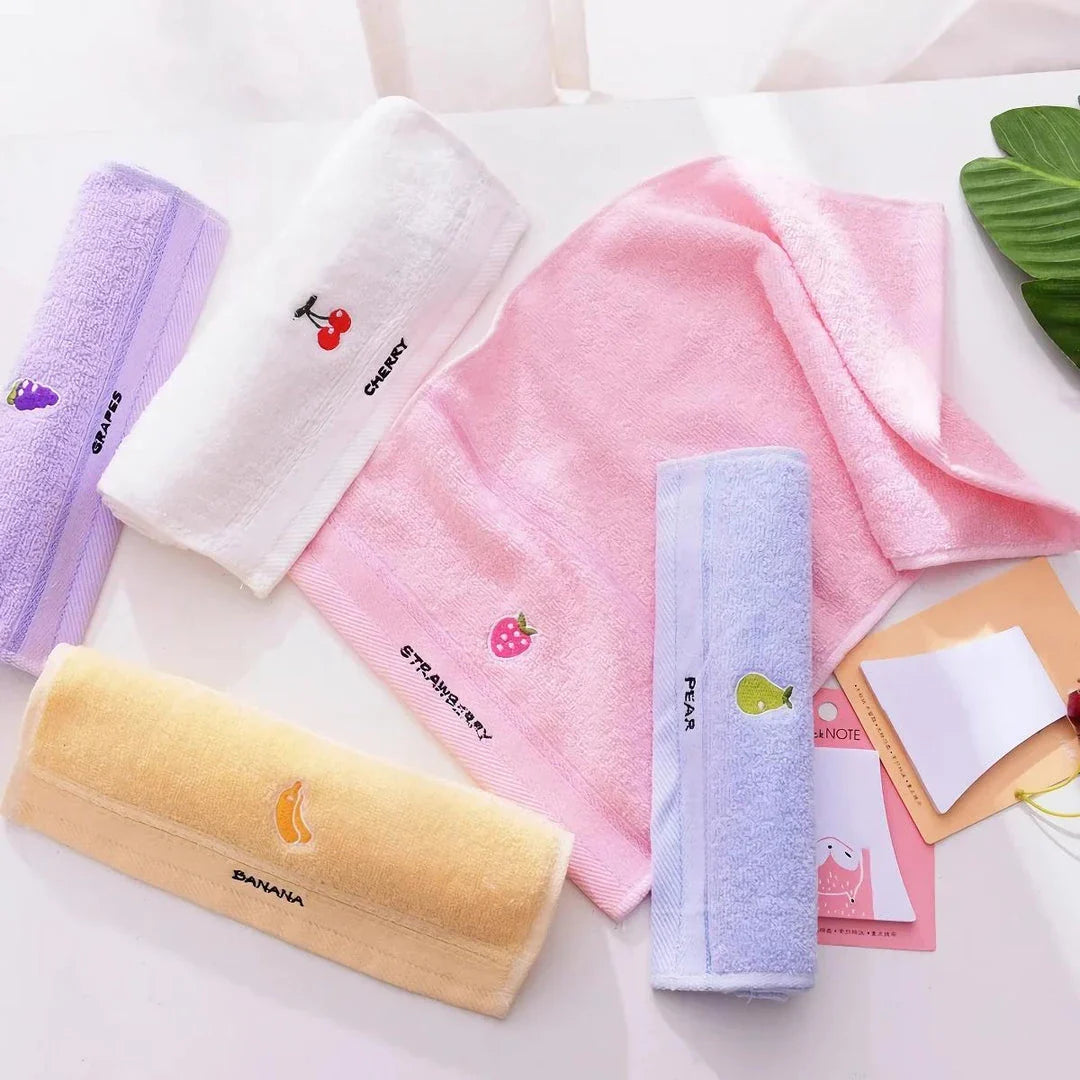 Soft cotton baby bath towel with adorable cartoon fruit face designs in pink