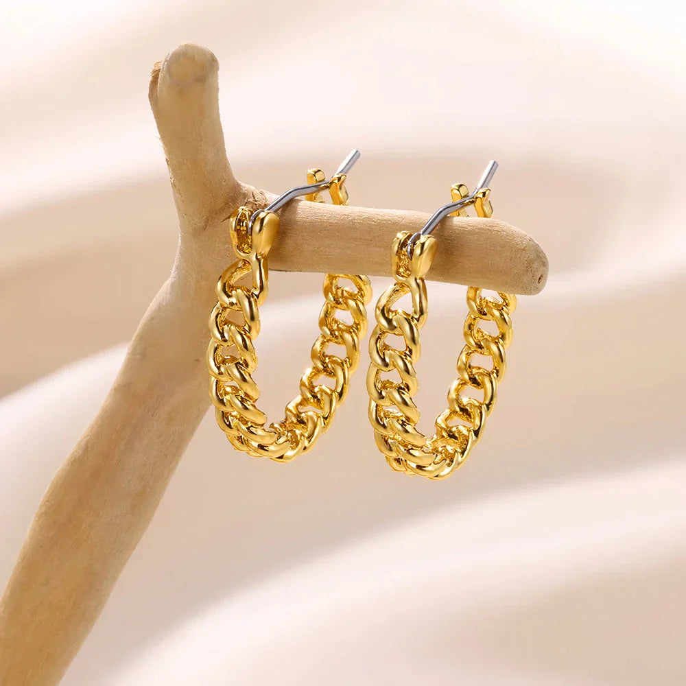 A pair of gold-toned stainless steel hoop earrings, showcasing a classic and sophisticated design
