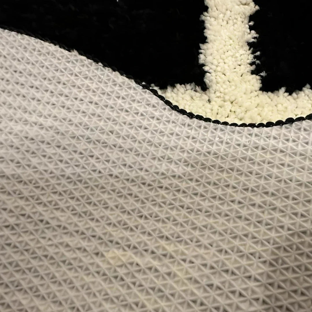 Tufted black and white geometric area rug with a soft, plush texture and anti-slip backing