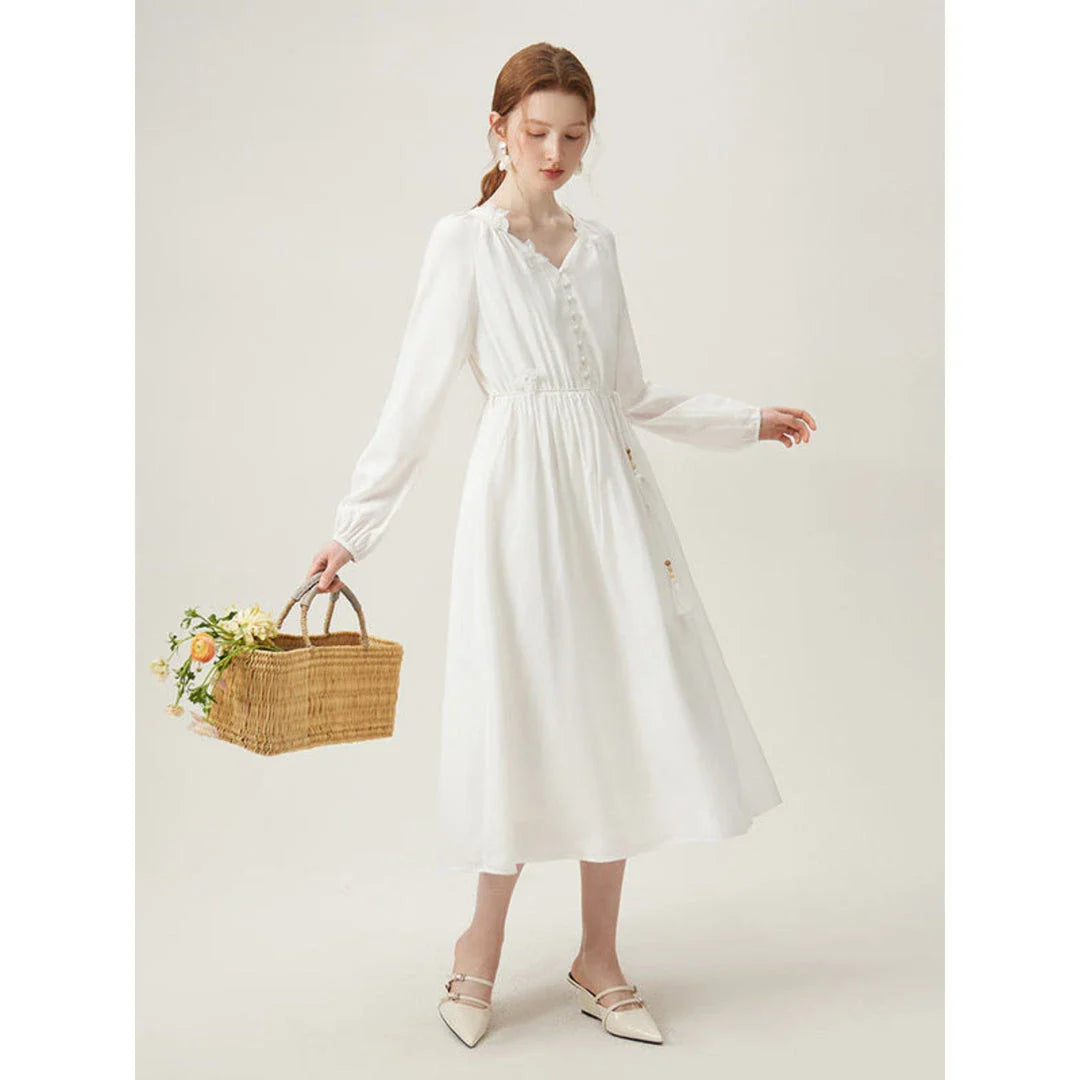 A woman wearing a long-sleeved, midi-length dress in a French pastoral style with an empire waistline and A-line silhouette.