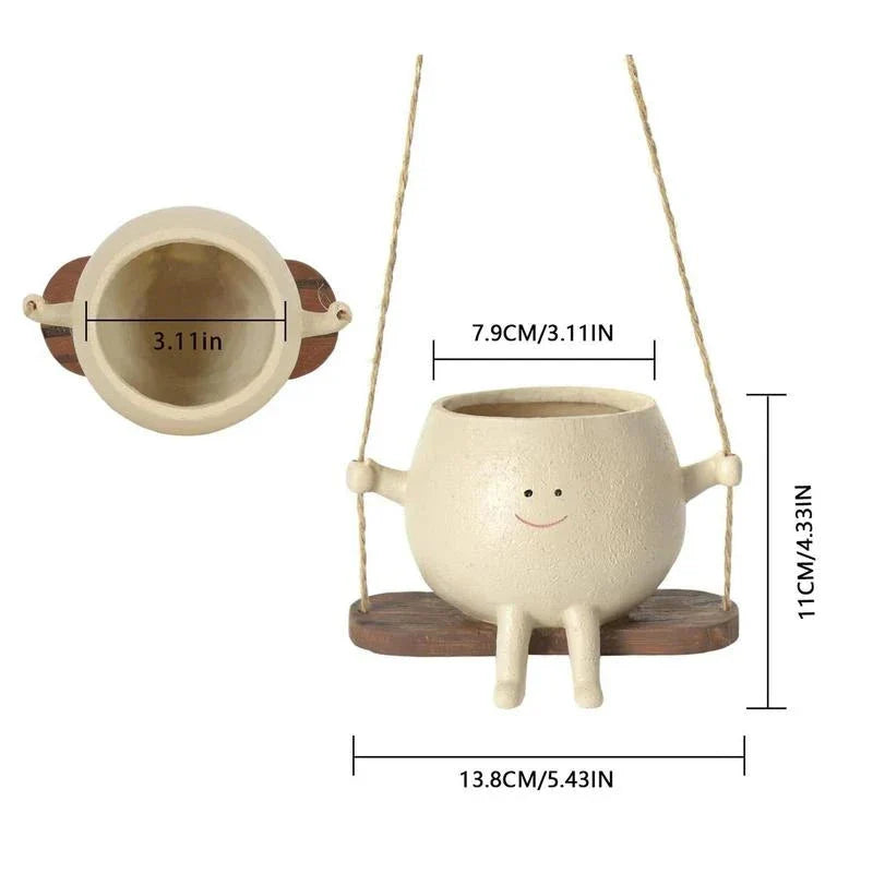 A white hanging planter with a charming, smiling child's face design, perfect for indoor or outdoor use.
