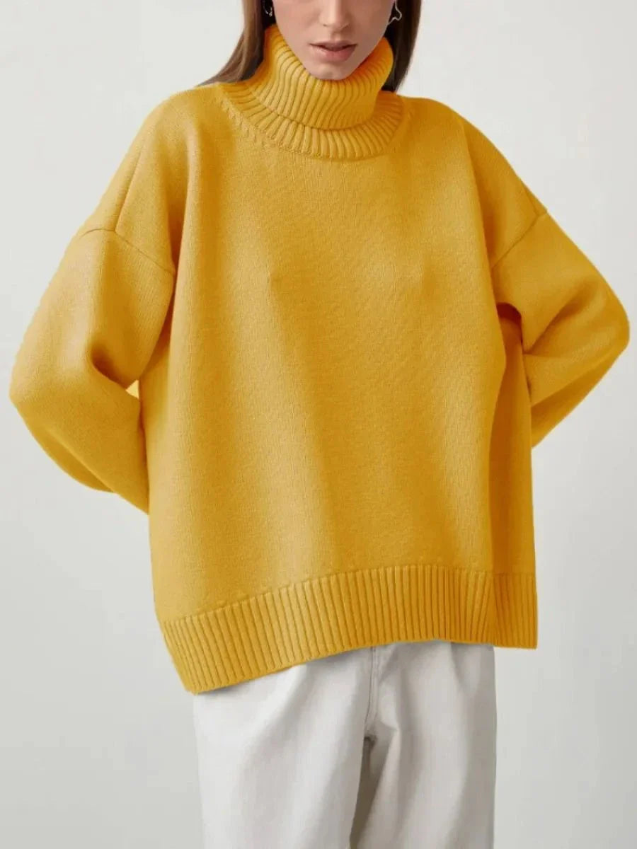 Cosy oversized knitted pullover in blue, featuring a classic turtleneck collar and drop-shoulder silhouette for maximum comfort and style.