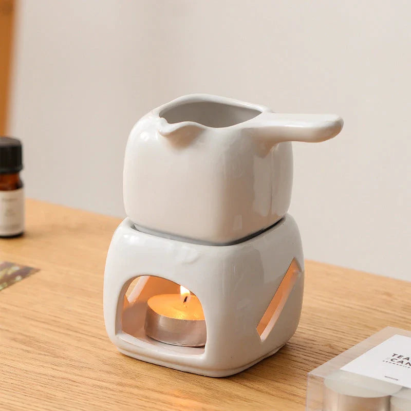 Elegant ceramic candle holder and tea warmer set in a classic square design with a wooden handle