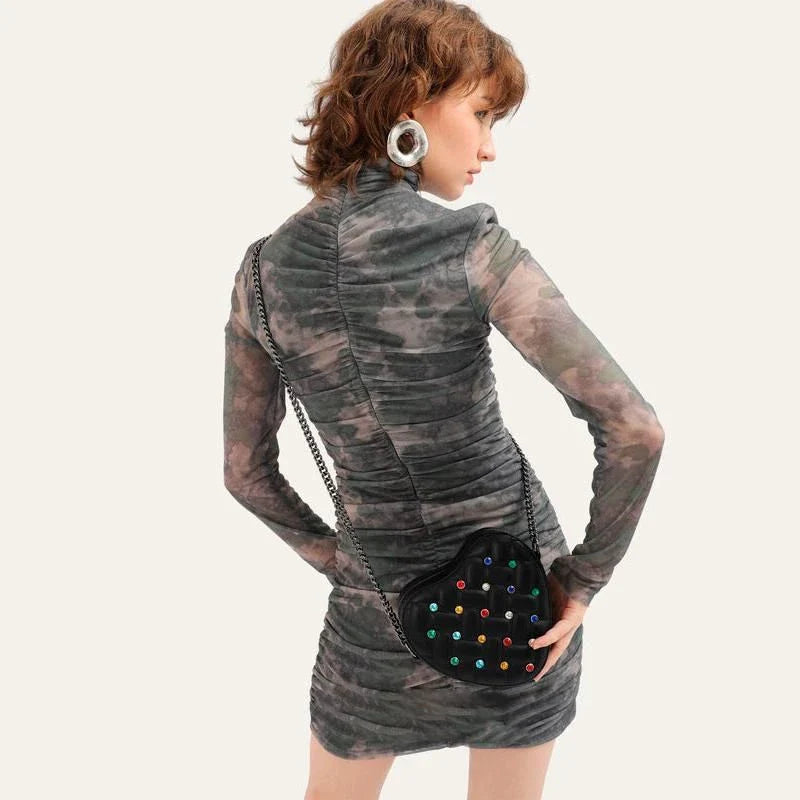 A stylish heart-shaped vegan leather crossbody bag with colourful rhinestone detailing, a versatile and fashionable accessory.