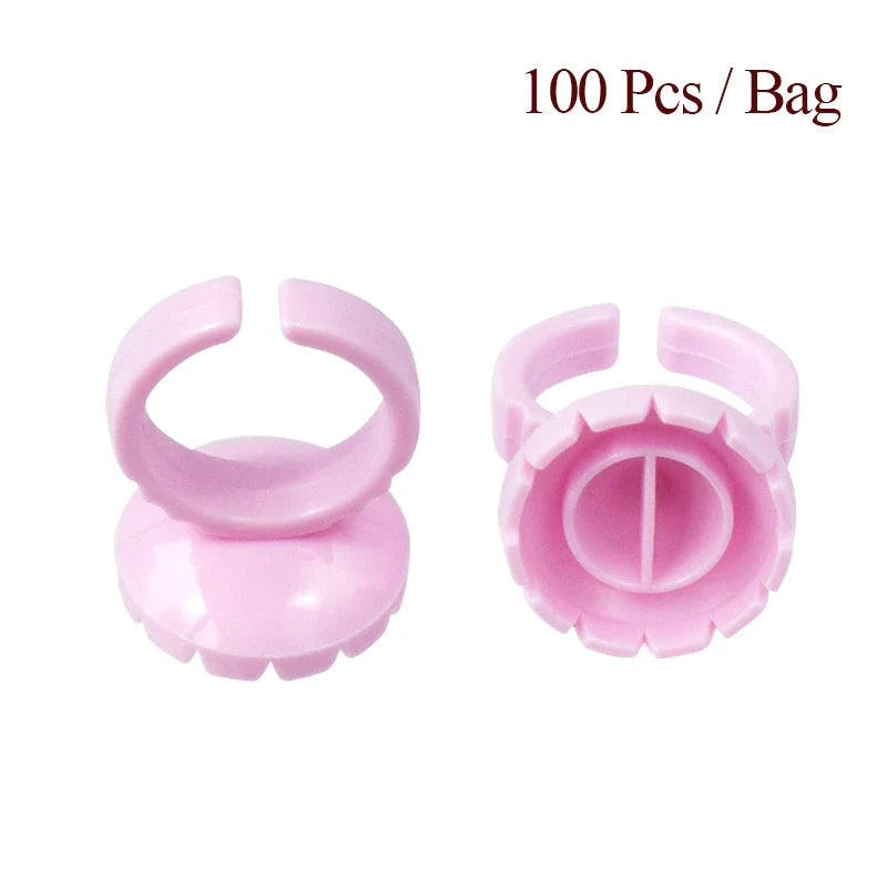 Heart-shaped disposable eyelash glue rings in blue, pink, and white colours