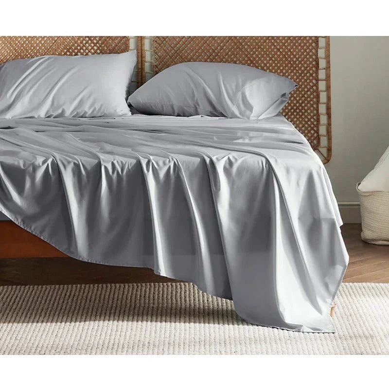 Premium bamboo fibre bed sheets in a classic solid purplish blue colour, featuring a four-piece set including a fitted sheet, flat sheet, and two pillowcases.