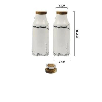 Ceramic salt and pepper shaker set with oil bottle in light grey porcelain finish, featuring minimalist design and easy-grip handles