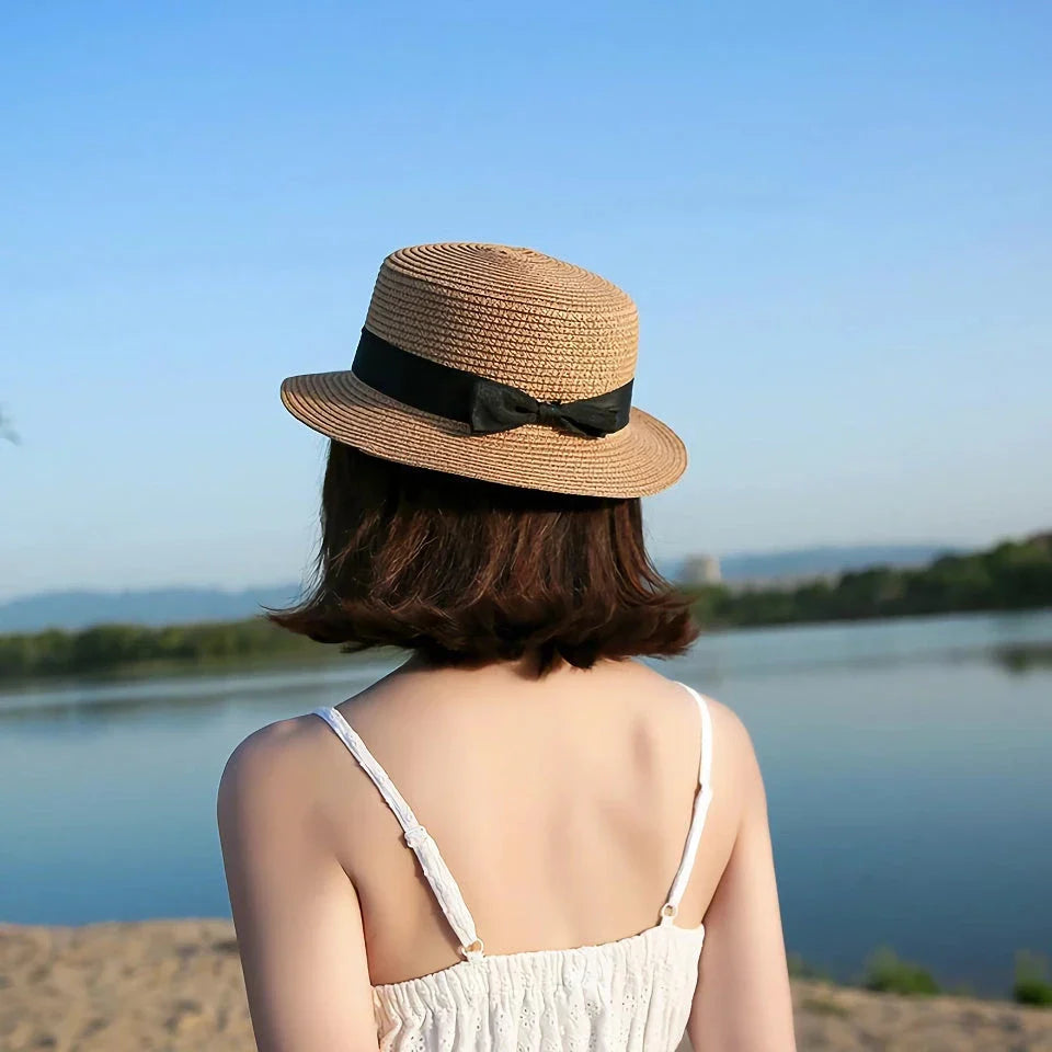 A classic summer Panama hat made from straw and paper, featuring a charming bow detail that adds a feminine touch.
