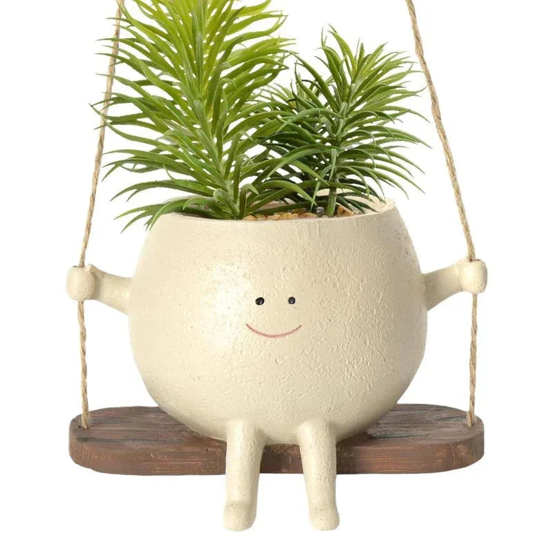 A white hanging planter with a charming, smiling child's face design, perfect for indoor or outdoor use.