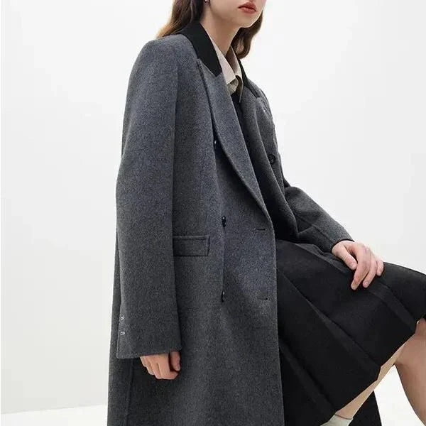 A sophisticated and stylish dark grey woollen coat for women, designed with a timeless double-breasted closure and notched collar.