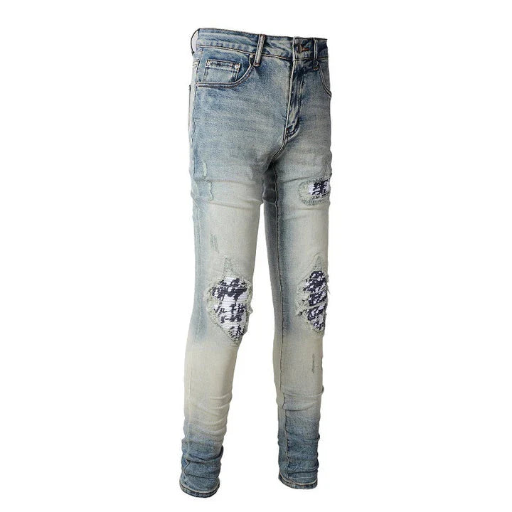 Stylish ripped denim jeans with a unique black and white patch design, perfect for British gentlemen