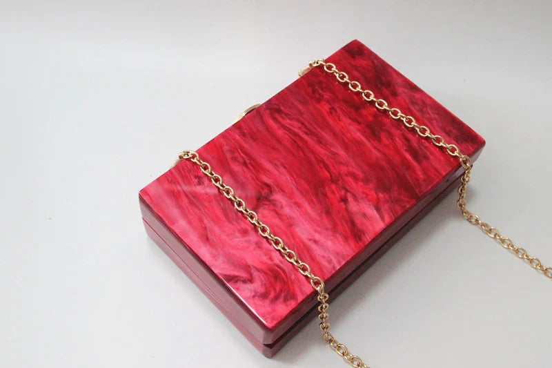 Stylish pearlescent acrylic clutch bag in red colour with a structured, square-shaped design