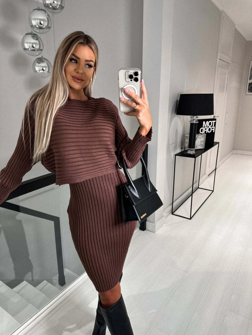 A 2-piece outfit featuring a long-sleeved striped top and a mid-length suspender skirt, perfect for autumn and winter fashion.
