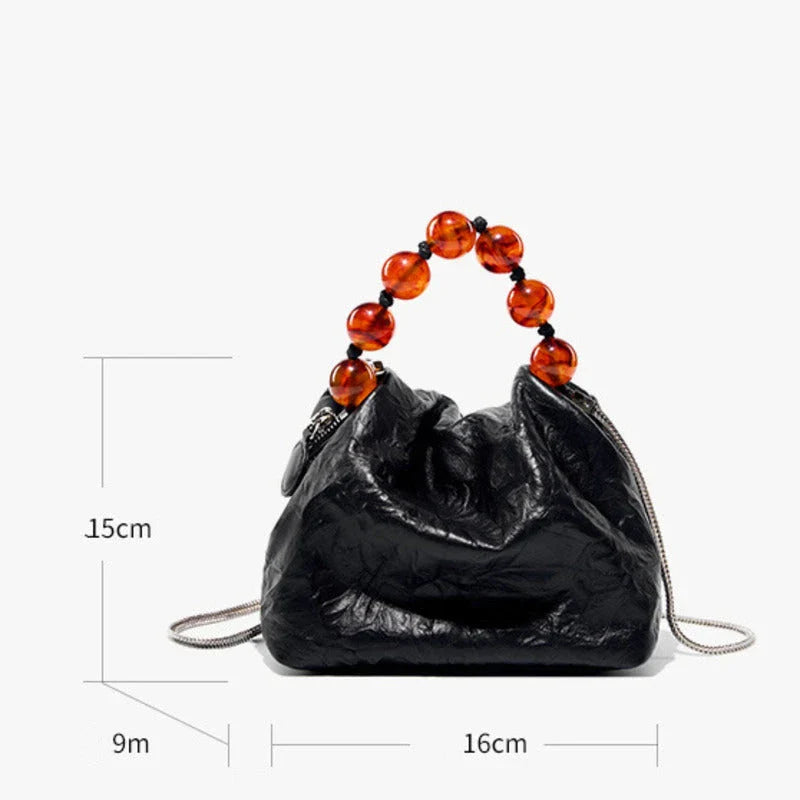 Premium leather crossbody bag with intricate beadwork, featuring a classic saddle shape and adjustable shoulder straps for versatile and secure everyday use.