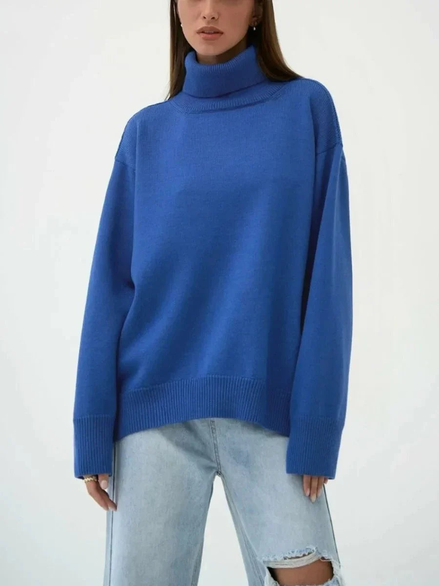 Cosy oversized knitted pullover in blue, featuring a classic turtleneck collar and drop-shoulder silhouette for maximum comfort and style.