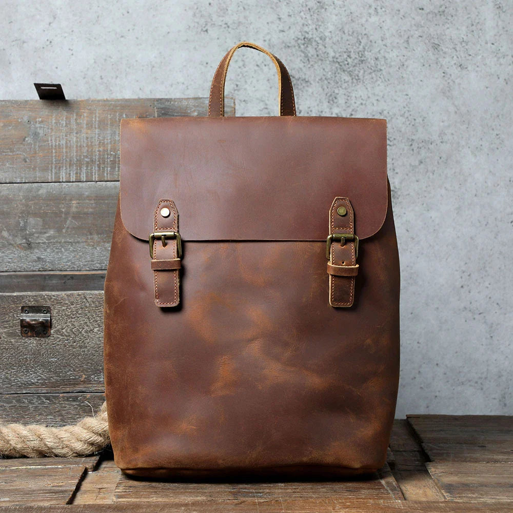 Premium vintage leather backpack with a classic design, featuring a spacious main compartment and adjustable padded shoulder straps for comfortable wear.