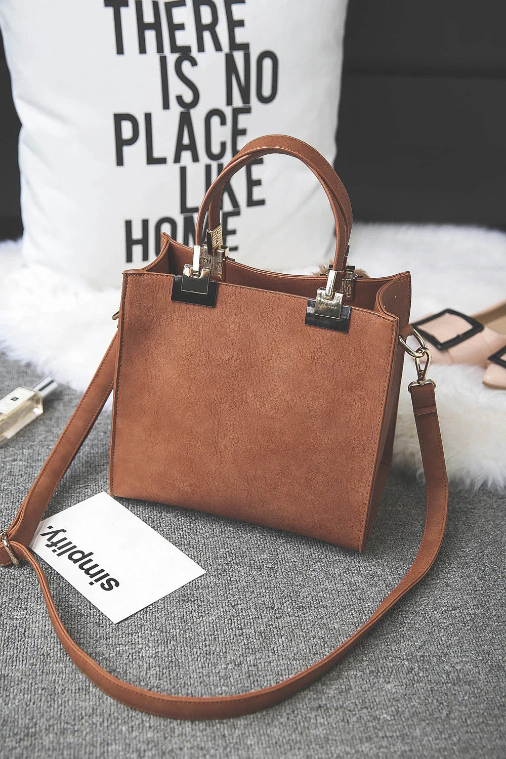 A stylish and versatile shoulder bag with a pom-pom accent, perfect for everyday use and special occasions.