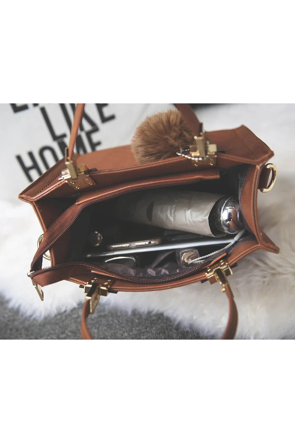A stylish and versatile shoulder bag with a pom-pom accent, perfect for everyday use and special occasions.