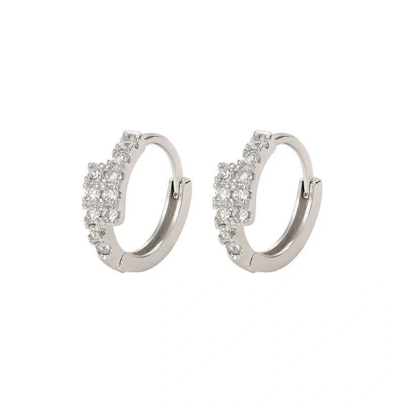 Elegant diamond-accented ear clips with a geometric design, showcasing refined British style.
