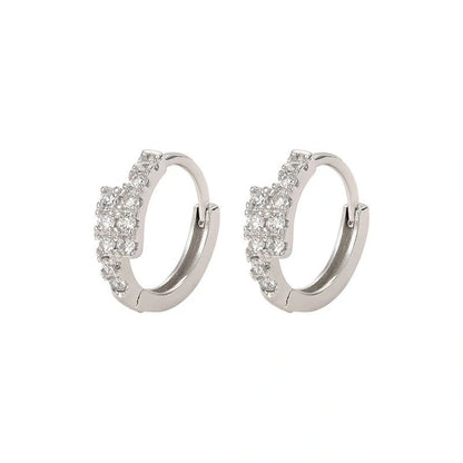Elegant diamond-accented ear clips with a geometric design, showcasing refined British style.