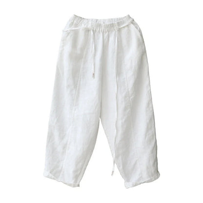Elegant white linen trousers with a relaxed, artistic silhouette and cropped length
