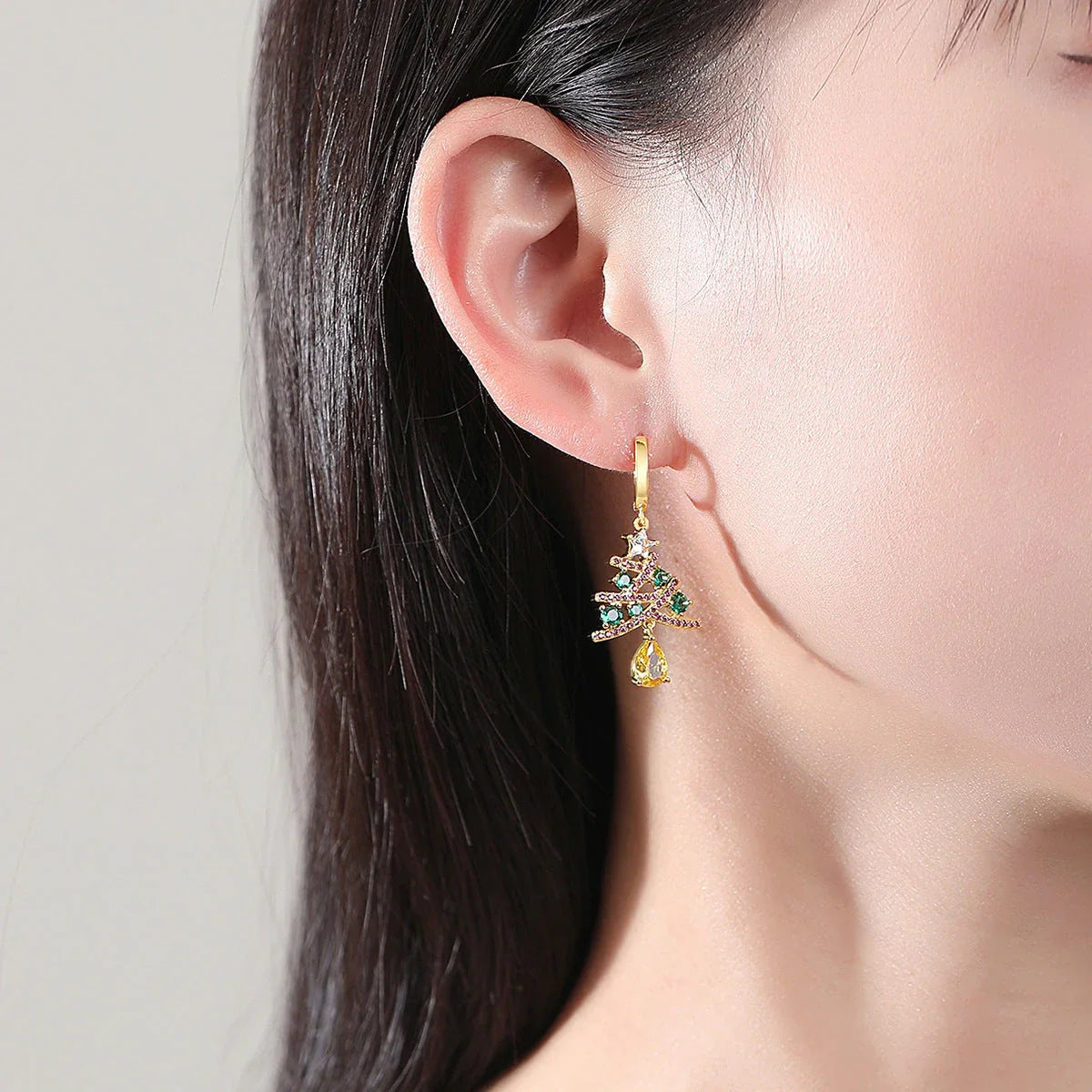 Pair of elegant Christmas tree earrings with a geometric design, sparkling rhinestones, and 18K gold electroplating