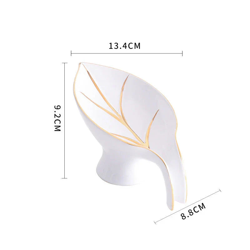 Elegant ceramic soap dish with leaf-shaped design, suction cup base, and drainage holes for bathroom storage and decor
