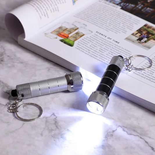 Compact LED keychain torch in four colours for emergencies and camping