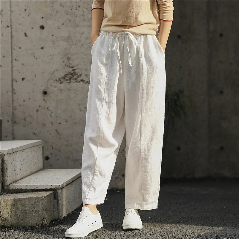 Elegant white linen trousers with a relaxed, artistic silhouette and cropped length