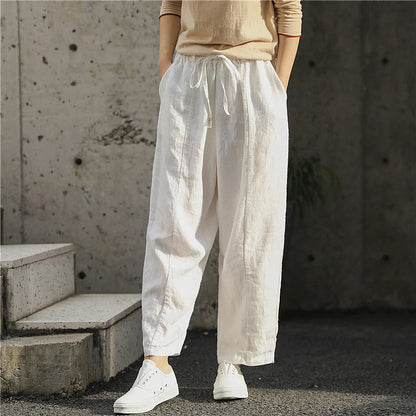 Elegant white linen trousers with a relaxed, artistic silhouette and cropped length