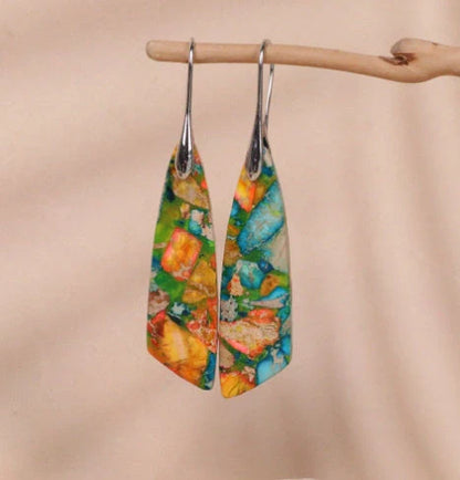 Geometric flower shape pendant earrings in copper with gold hooks, available in red, green, and blue.