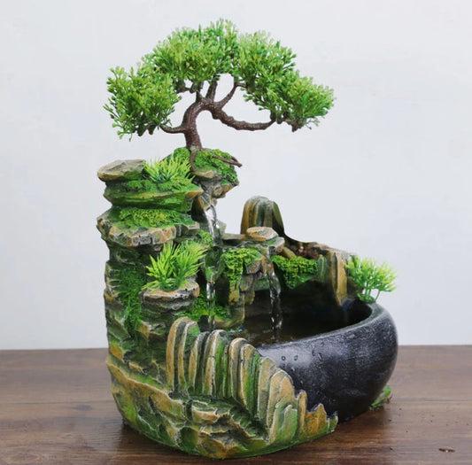 A desktop water feature with a rockery design, flowing water, and an optional mist function for creating a calming and relaxing ambience in home or office spaces.