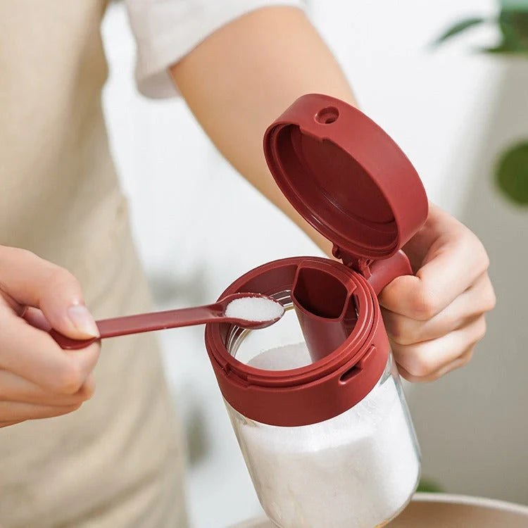 Small glass seasoning jars with lids and built-in spoons for easy measuring and storage