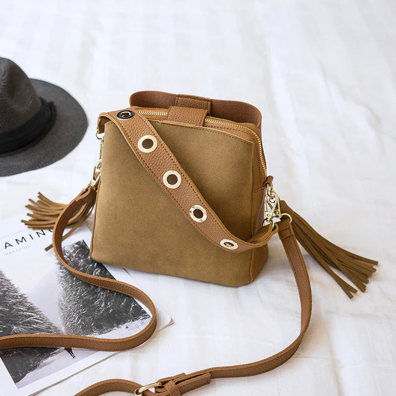 Trendy frosted tassel bucket bag in a range of classic colors, featuring a spacious interior and a dedicated camera pocket for maximum convenience.
