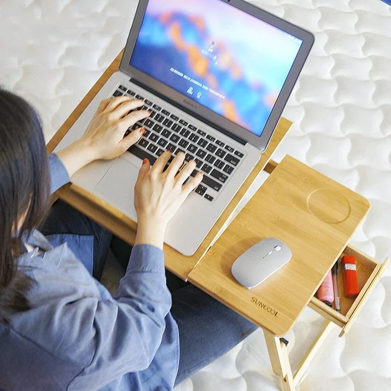 Ergonomic bamboo laptop desk with storage drawers, adjustable legs, and cooling fan for comfortable home office use