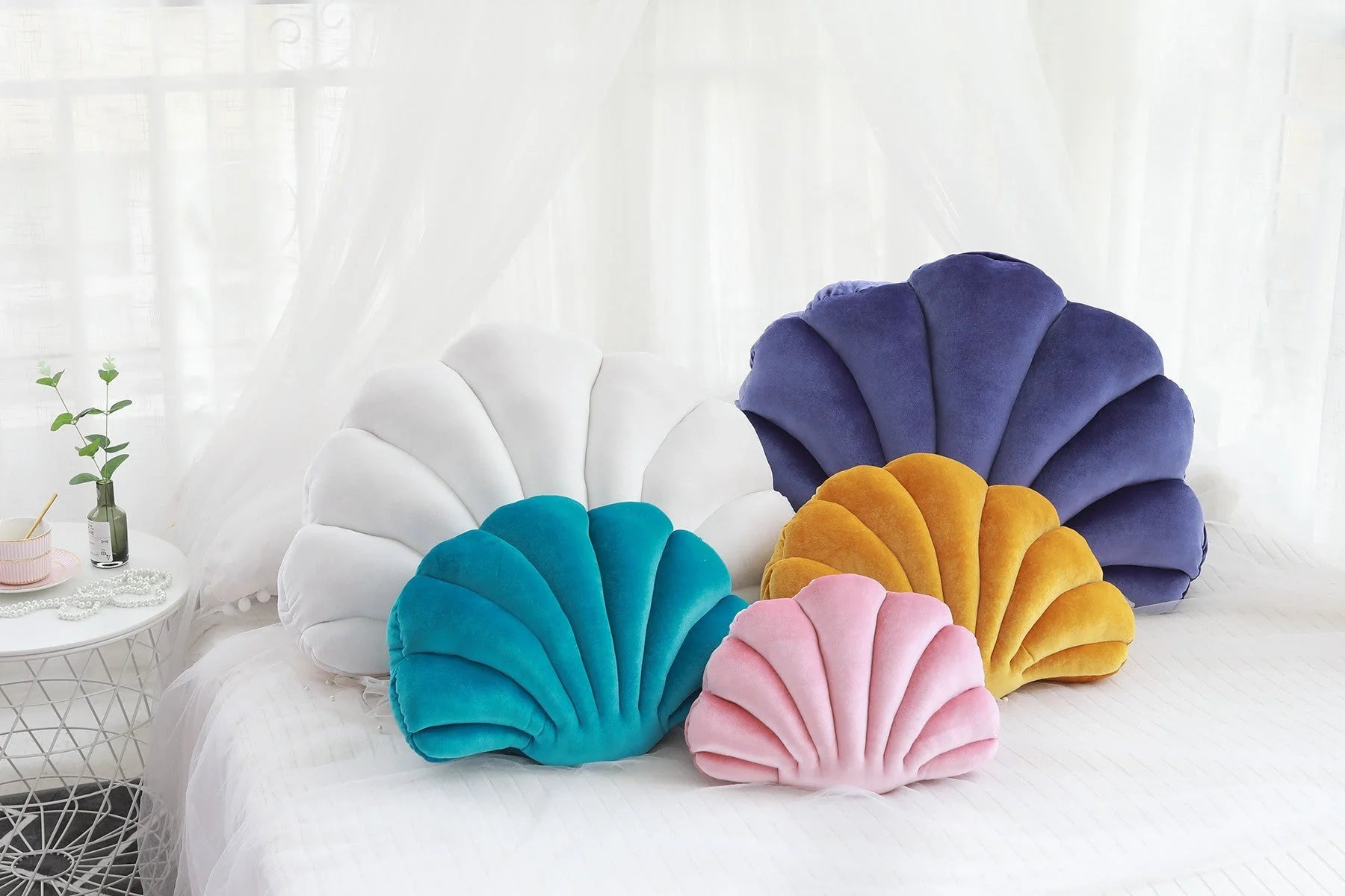 Cosy shell-shaped plush nap pillow in various colours and sizes for ultimate comfort