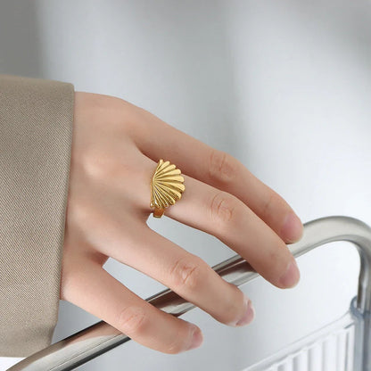 Ocean Style Scallop Ring in titanium steel and gold finishes, showcasing geometric design inspired by the sea.