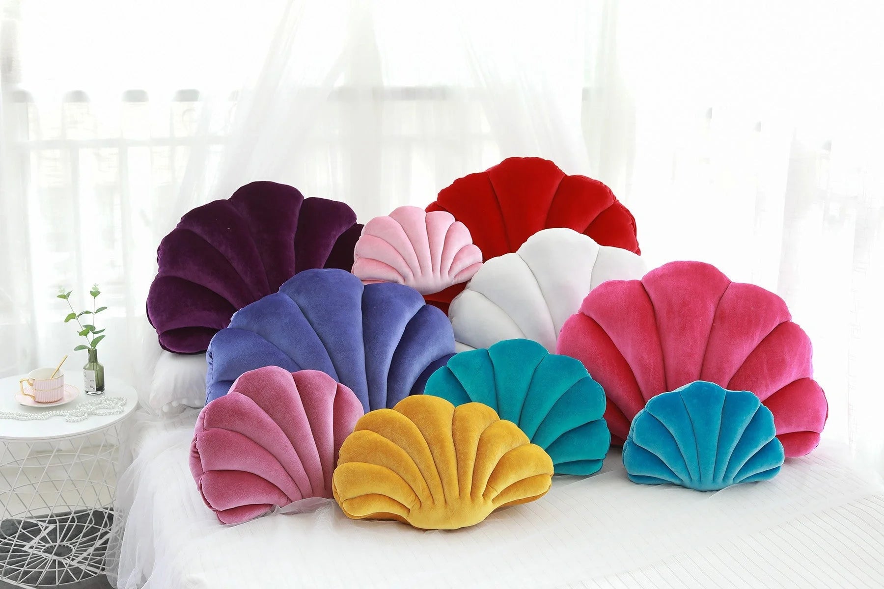 Cosy shell-shaped plush nap pillow in various colours and sizes for ultimate comfort