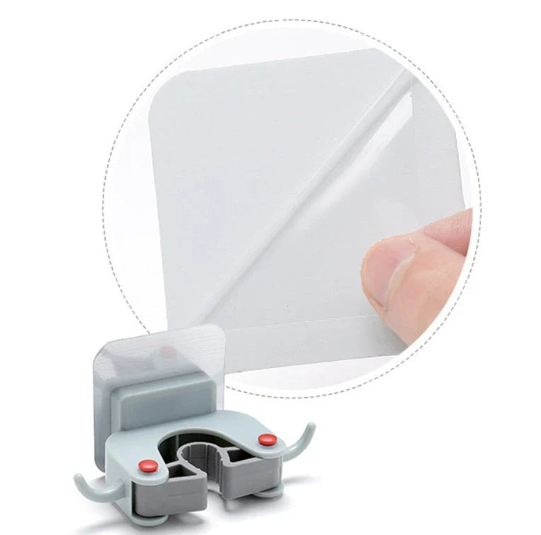 Adhesive wall-mounted mop and broom holder with double hooks for storing cleaning tools, available in multiple colors.