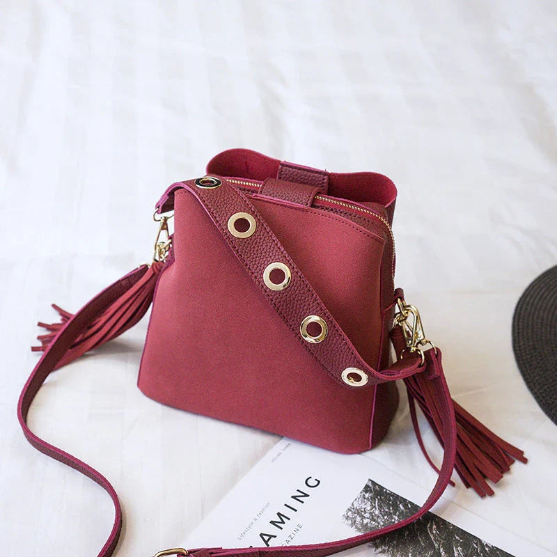 Trendy frosted tassel bucket bag in a range of classic colors, featuring a spacious interior and a dedicated camera pocket for maximum convenience.