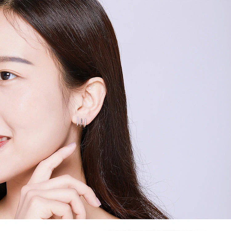 Elegant three-layer sterling silver heart earrings with sparkling gems, perfect for any occasion.