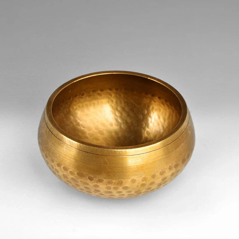 A handcrafted Tibetan singing bowl made of copper, used for meditation and relaxation.