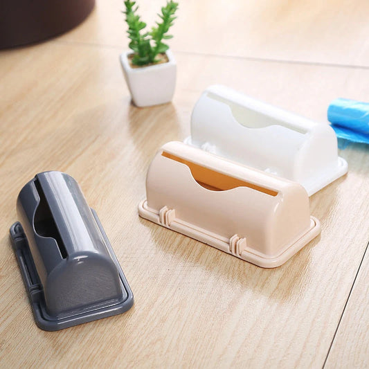 Wall-mounted plastic garbage bag holder in white, grey, or pink for kitchen organisation