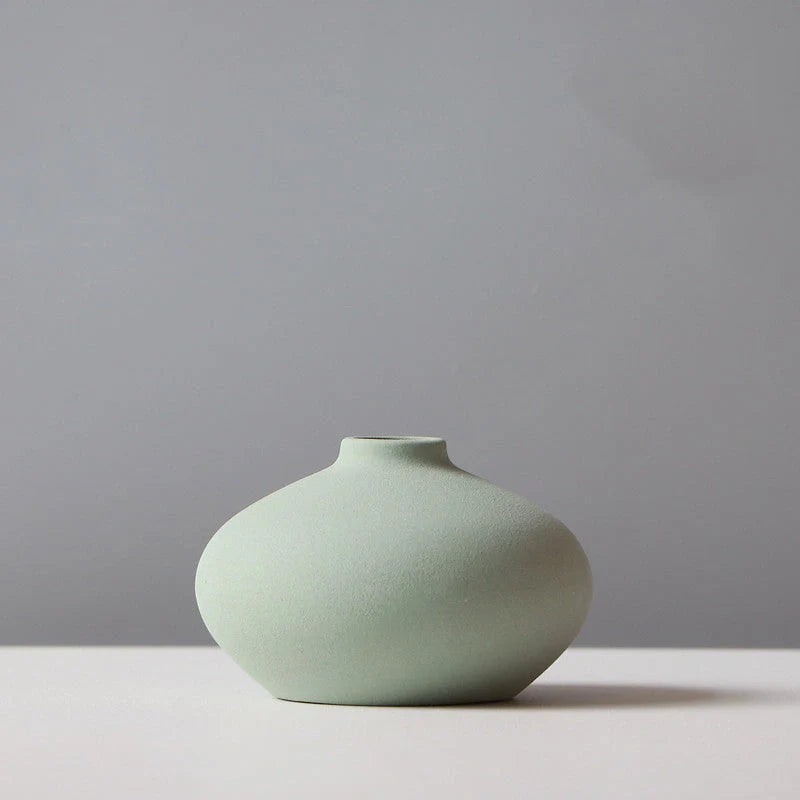 Ceramic vase in various colours, including brown, black, green, and orange, showcasing a minimalist Scandinavian design that is perfect for living room decor.