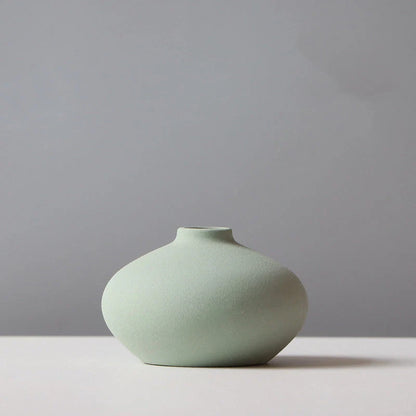 Ceramic vase in various colours, including brown, black, green, and orange, showcasing a minimalist Scandinavian design that is perfect for living room decor.