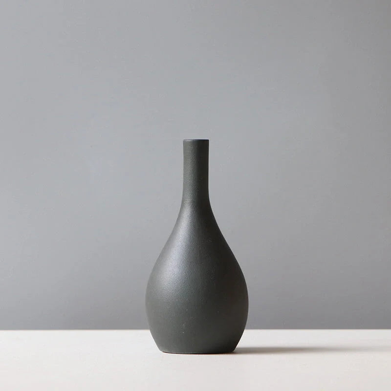 Ceramic vase in various colours, including brown, black, green, and orange, showcasing a minimalist Scandinavian design that is perfect for living room decor.